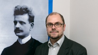 Тимо Виртанен с 1997 года работает главным редактором по произведениям Жана Сибелиуса в Национальной библиотеке Финляндии. Он думает, что на день рождения гениальный композитор хотел бы услышать, что его высоко ценимая работа собрана в одно критическое издание. Пока опубликованы 26 частей из общего числа 52. «Было бы великолепно предоставить ему все опубликованные части и дать обещание, что со временем он получит и все остальные.»