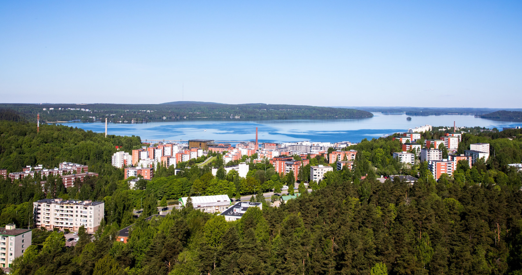 A panoramic view of a city beside a lake.