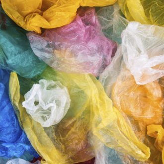 Sacos plásticos de várias cores misturados.