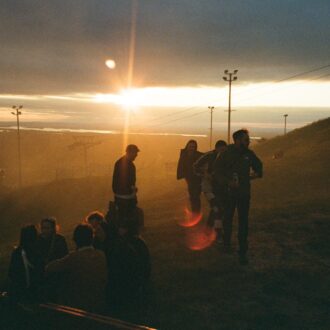 Festival guests hanging out on a ski slope in the summer under the midnight sun.